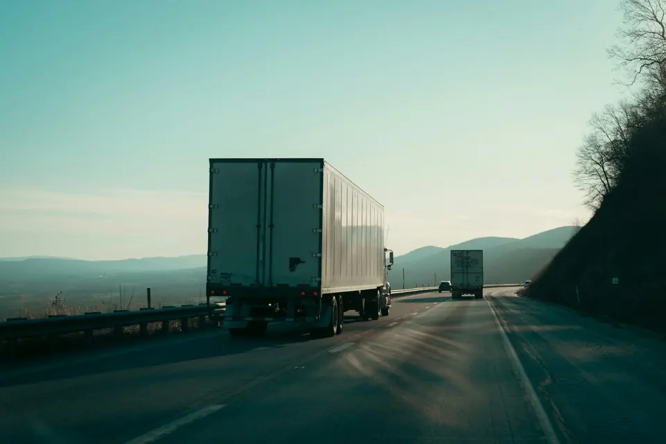 Two trucks traveling on a highway